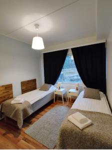 万塔Kotimaailma - Saunallinen kolmio lähellä lentokenttää的一间卧室设有两张床和大窗户