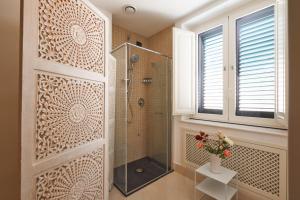 陶尔米纳Corvaja Inn的带淋浴的浴室和玻璃门