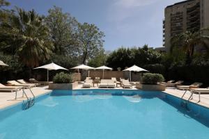 门多萨门多萨柏悦水疗赌场酒店的一个带椅子和遮阳伞的大型游泳池