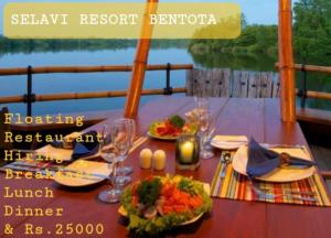 本托塔Selavi Resort Bentota的船上的餐桌,上面摆放着食物和酒杯
