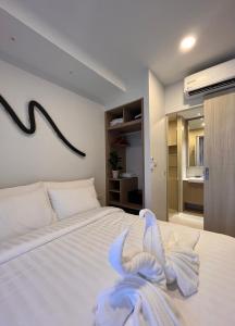 他朗2 br Laguna, SkyPark, Bang Tao的卧室配有白色的床和毛巾