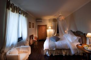Buttrio茶乐维涅民宿的卧室配有床、椅子和窗户。