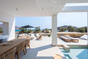 莫罗斯帕罗Exclusive Luxury Moca beachfront villa, Molos, Paros的户外庭院配有木桌和椅子