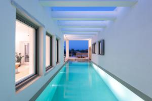 莫罗斯帕罗Exclusive Luxury Moca beachfront villa, Molos, Paros的一座带窗户的建筑中央的游泳池