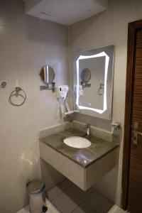 沃季赫Taj Al-Wajh Hotel的一间带水槽和镜子的浴室