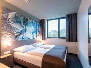 慕尼黑B&B Hotel München-Olympiapark的一间卧室配有一张壁画床