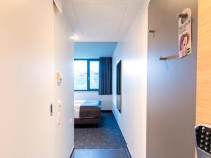 慕尼黑B&B Hotel München-Olympiapark的走廊通往带床的房间