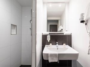 慕尼黑B&B Hotel München-Olympiapark的白色的浴室设有水槽和淋浴。