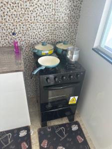 萨夸雷马Casa Onda Azul 1的厨房配有带锅碗瓢盆的炉灶。