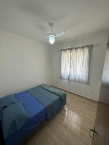 萨夸雷马Casa Onda Azul 1的一间卧室配有一张床和吊扇