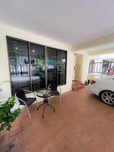 Bang KapiSukhumvit 31 Sweet Home 7 beds - up to 12 guests的庭院配有桌椅和汽车。