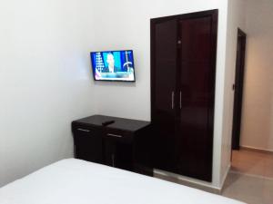 达赫拉HOTEL NASSIM AL-BAHR的卧室配有一张床,墙上配有电视。