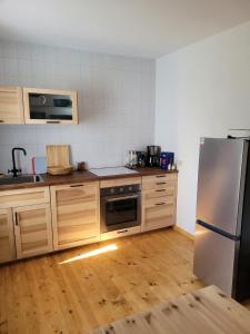 霍恩斯泰因Einkehr zur Rennstrecke的厨房配有不锈钢冰箱和木地板