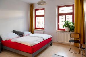 德绍Karl die Große Ferienwohnung的卧室设有红色和白色的床和窗户。