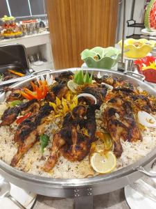 沃季赫Taj Al-Wajh Hotel的盘子上放着鸡和蔬菜的米饭