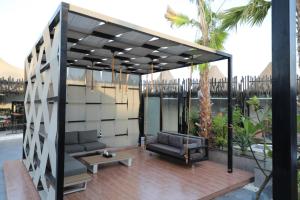 沃季赫Taj Al-Wajh Hotel的凉亭配有一张沙发和一个位于庭院的桌子
