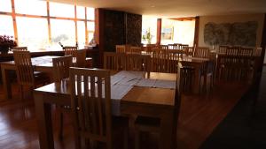 科伊艾科Coyhaique River Lodge的用餐室设有木桌、椅子和窗户。