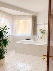 施马伦贝格Hotel Stockhausen GbR的白色的浴室设有浴缸和窗户。