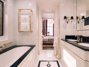 维也纳维也纳萨赫酒店的浴室配有两个盥洗盆和浴缸。