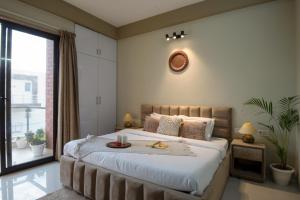 古尔冈BedChambers Serviced Apartment, Medicity的一间卧室设有一张大床和一个大窗户