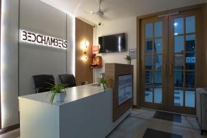 古尔冈BedChambers Serviced Apartment, Medicity的办公室,设有接待台和读竹的标志