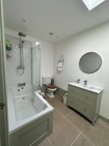金斯林The Penthouse at Purfleet的带浴缸、盥洗盆和卫生间的浴室