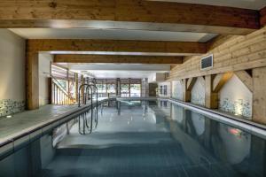 阿克1800Belambra Clubs Arc 1800 - Hôtel Du Golf的大型游泳池设有木制天花板和大窗户