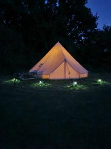 IfieldGlamping in style Bell tent的夜晚在田野里带灯的帐篷