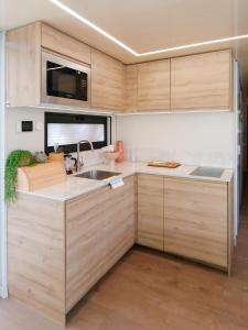 比得哥什Dom na wodzie LaMare Modern 14的一个带木制橱柜和水槽的厨房