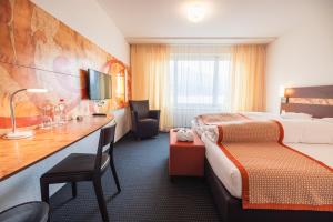 瓦伦施塔特席浩思高级酒店的配有一张床和一张书桌的酒店客房