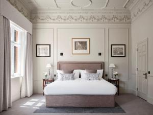 伦敦11 Cadogan Gardens, The Apartments and The Chelsea Townhouse by Iconic Luxury Hotels的一间卧室配有一张带白色床单和天花板的床。