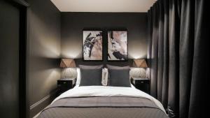 曼彻斯特Midnight by The Heim Residences的卧室配有一张墙上三幅照片的床