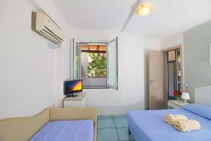 伊斯基亚La Turrita Apartments的一间卧室设有两张床、一台电视和一扇窗户。