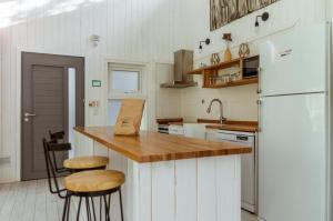 拉安戈斯图拉镇BOG Nórdica 2的厨房配有白色冰箱和带凳子的台面