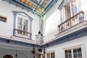 赫雷斯-德拉弗龙特拉PALACIO DON CARLOS的客房设有2扇窗户和彩色玻璃天花板。