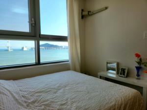 釜山Hot place的一间卧室设有一张床和一个大窗户