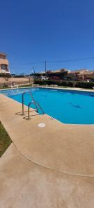 米哈斯Piso junto al Faro de Calaburras - Mijas Costa的一个带扶手的大型蓝色游泳池