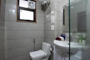 古尔冈Serviced Apartment near Medanta by BedChambers的一间带卫生间、水槽和窗户的浴室