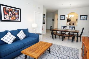 奥兰多Windsor Hills Resort- 204A的客厅配有蓝色的沙发和桌子