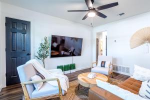 法默斯布兰奇Living in a Greenhouse - City Retreat - 3BR with 70 inches TV的客厅配有沙发、椅子和吊扇