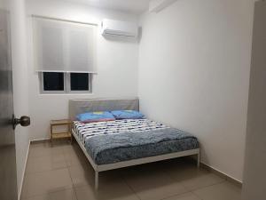 大山脚METROPOL SERVICED APARTMENT at Bukit Mertajam, Pulau Pinang的一间卧室配有一张带蓝色枕头的床。