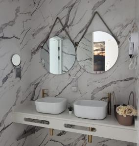 明德卢Ouril Mindelo的浴室设有2个水槽和大理石墙面的镜子。