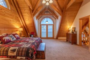 班纳埃尔克Elk Ridge Lodge的一间卧室设有一张床和木制天花板