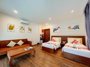 拉迈Aura Samui Best Beach Hotel - SHA Plus的酒店客房设有两张床和一张桌子。