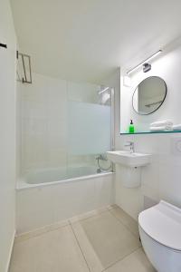 Saint-Aubin平衡骑士酒店的带浴缸、盥洗盆和卫生间的浴室