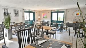 Saint-Aubin平衡骑士酒店的用餐室设有桌椅和窗户。