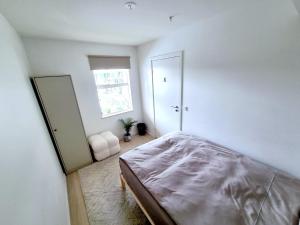 奥斯陆Private room in shared Modern Apartment - Oslo Hideaway的一间卧室设有一张床、一个窗口和一面镜子
