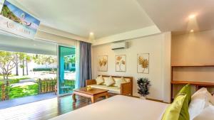 拉迈Aura Samui Best Beach Hotel - SHA Plus的一间卧室配有一张床、一张沙发和一张桌子