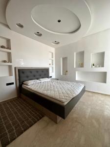 阿加迪尔Luxueuse appartement的一间卧室设有一张带天花板的大床