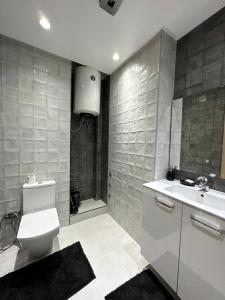 阿加迪尔Luxueuse appartement的浴室配有卫生间、盥洗盆和淋浴。